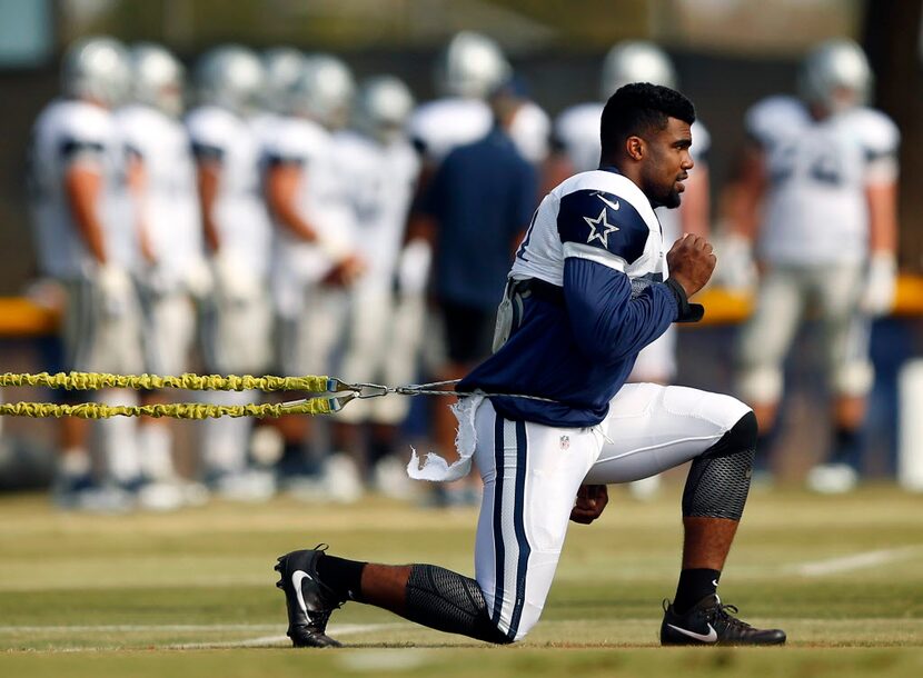 Dallas Cowboys running back Ezekiel Elliott (21) works with a resistance bungee during...