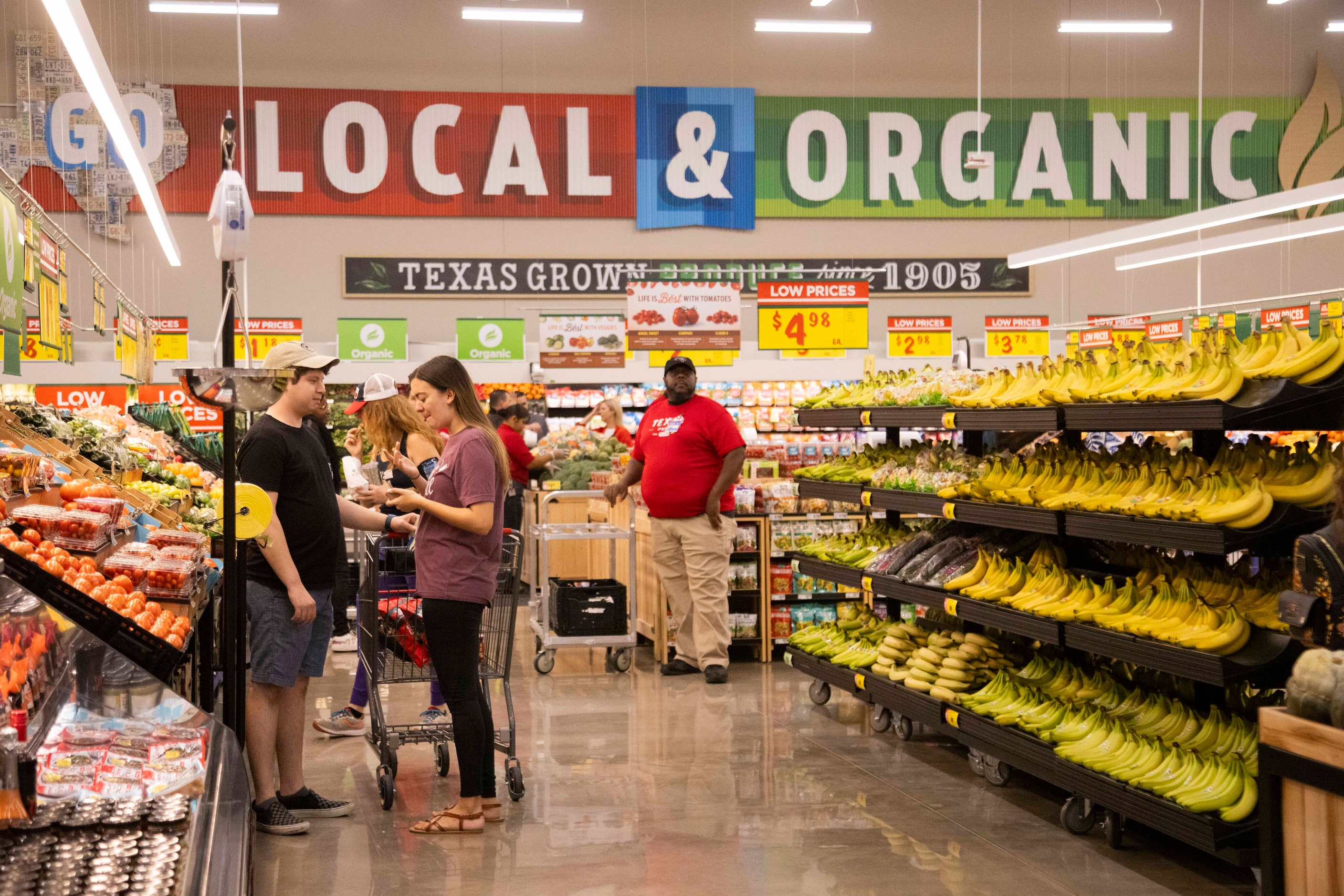 Customers shop the produce section during the grand opening of the H-E-B store in Allen on...