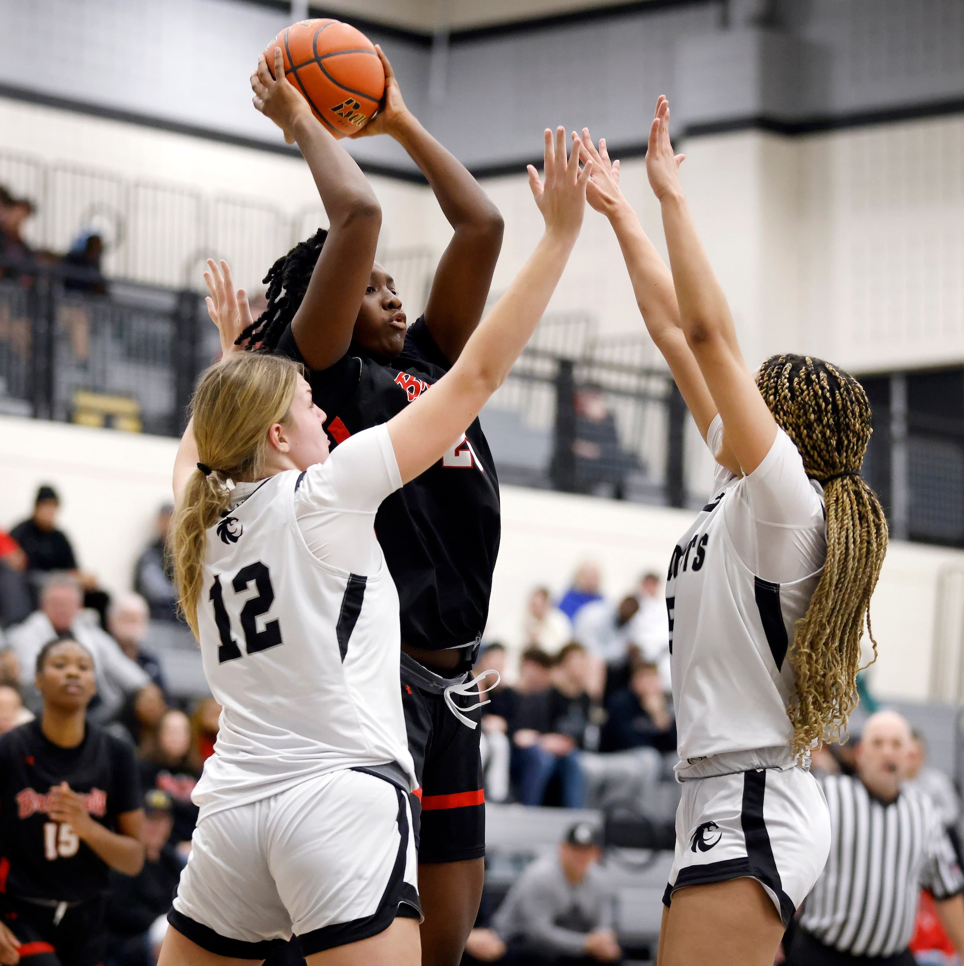 Denton Braswell center Amaya McDonald (25) passes as she is covered by Denton Guyer’s Audrey...