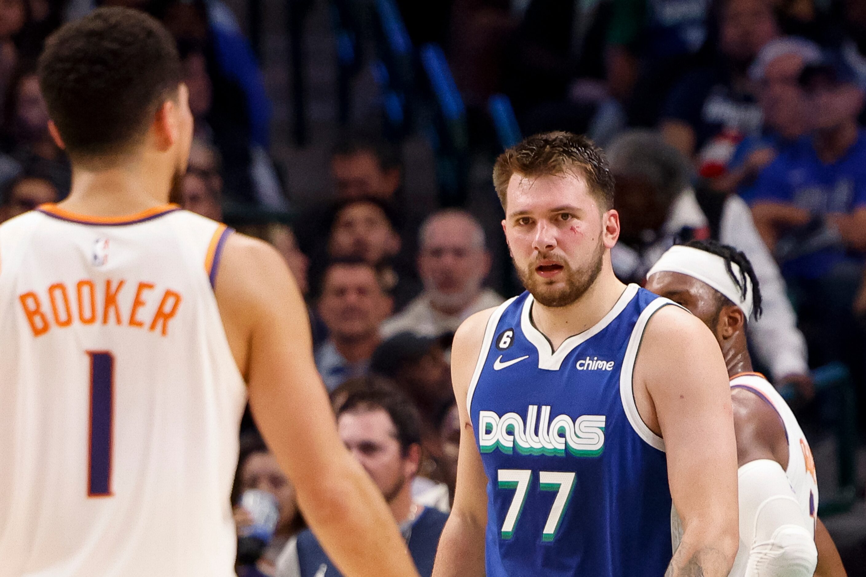 Dallas Mavericks guard Luka Doncic (77) looks at Phoenix Suns guard Devin Booker (1) after...