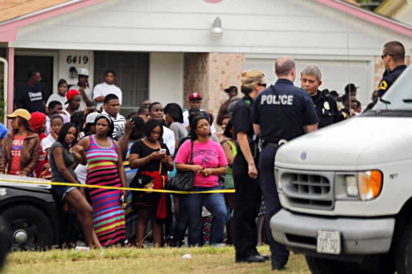 Dozens gathered outside a home on Frosty Trail in southeast Oak Cliff on Tuesday after two...