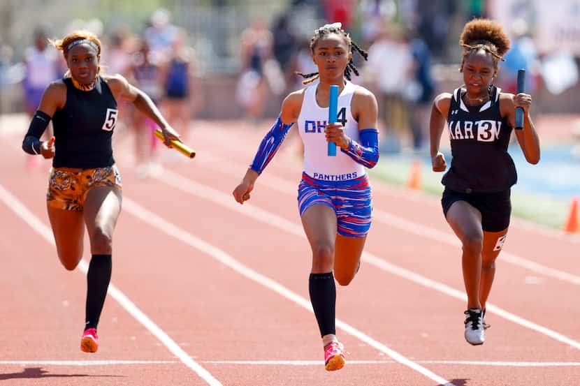 Duncanville’s Sanyah Keeton (center) runs to a win in the girls 4x100 meter relay ahead of...