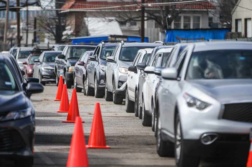 People in a long line of cars get ready for their second doses at Fair Park in Dallas County...