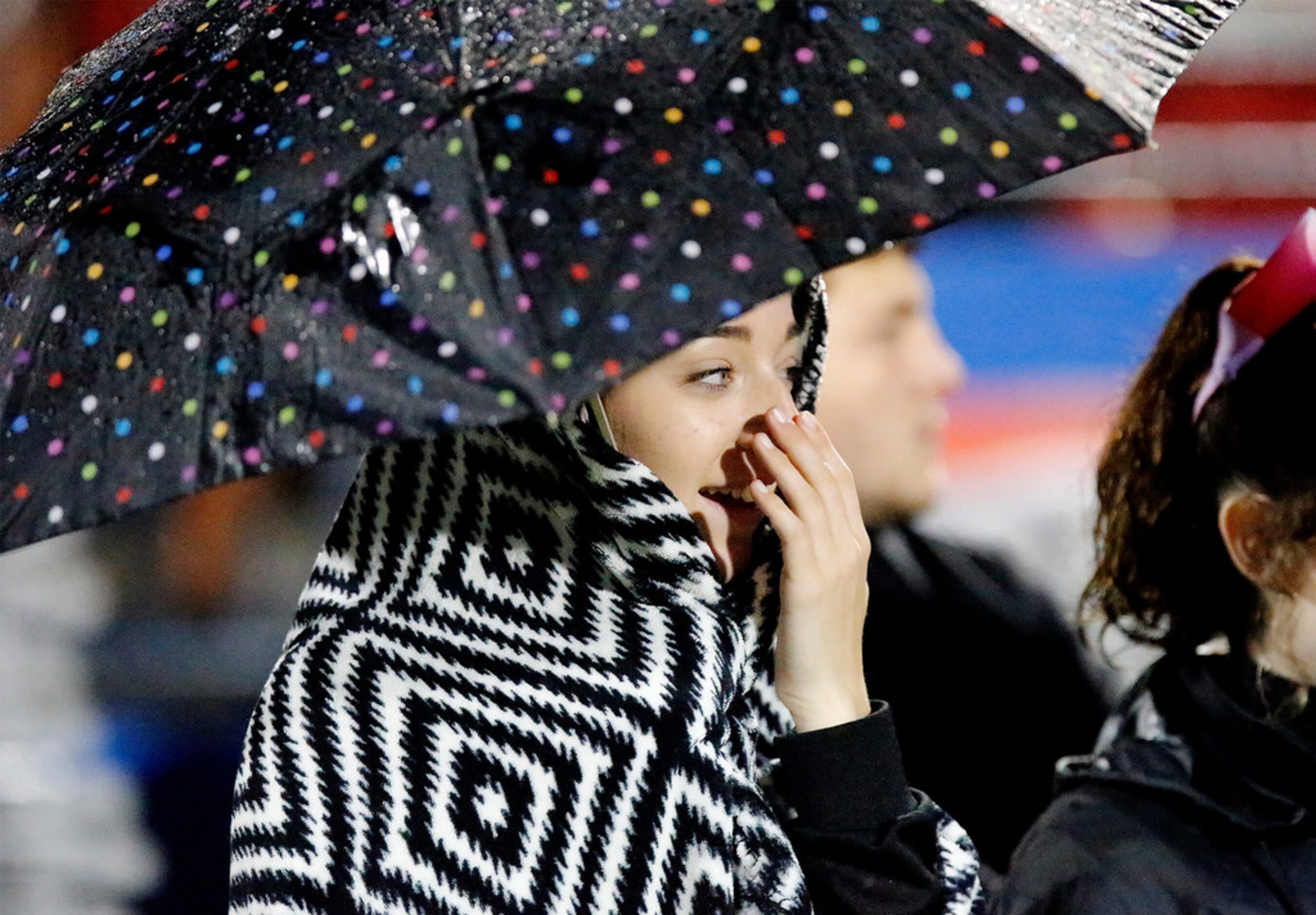 The Colony High School freshman cheerleader Haley Hobbs, 14, tries to keep warm and dry...