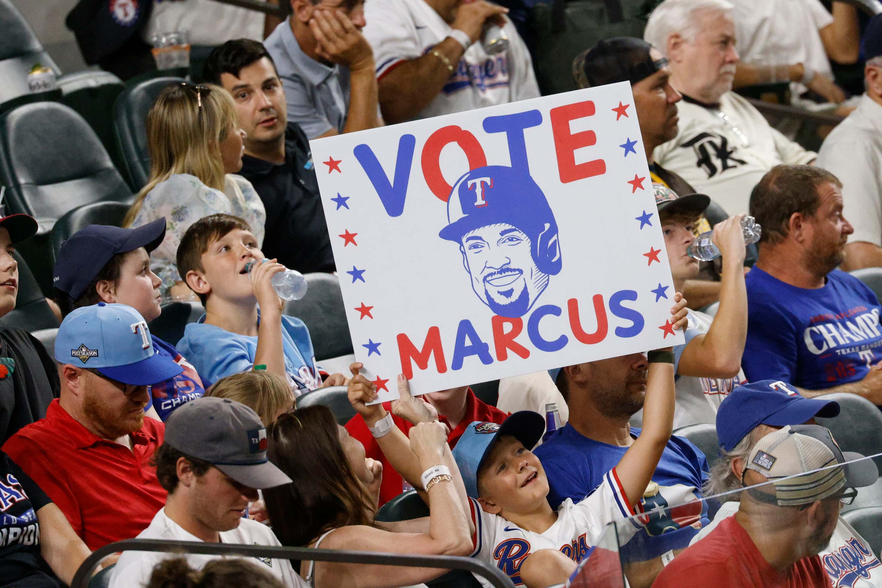 A Texas Rangers’ fan holds a sign before the seventh inning of a baseball game against the...