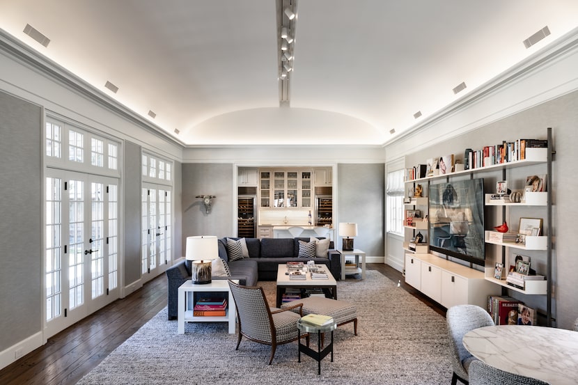 Living room with large area rug, sectional couch, chairs, and an entertainment center.