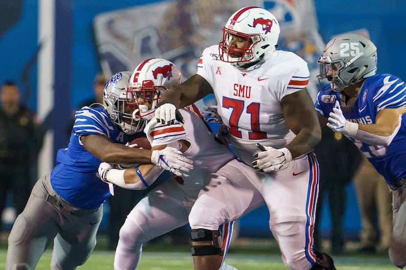 SMU running back Xavier Jones (5) is brought down by Memphis linebacker Tim Hart (35) as SMU...