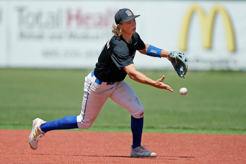 Jackson Holliday tosses the ball to second base during a Stillwater High School baseball...