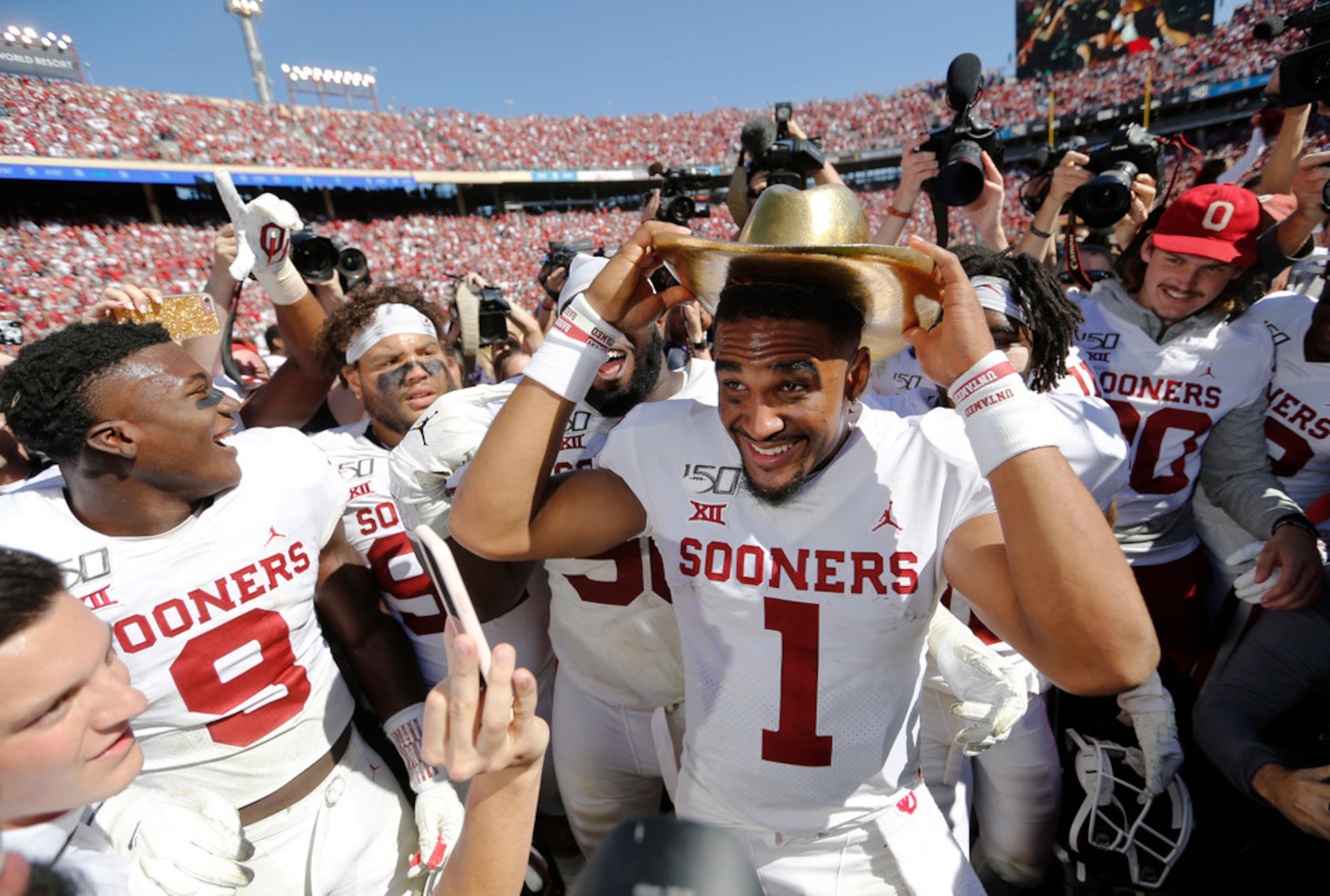 Oklahoma Sooners quarterback Jalen Hurts (1) tries on the Golden Hat as he celebrates with...