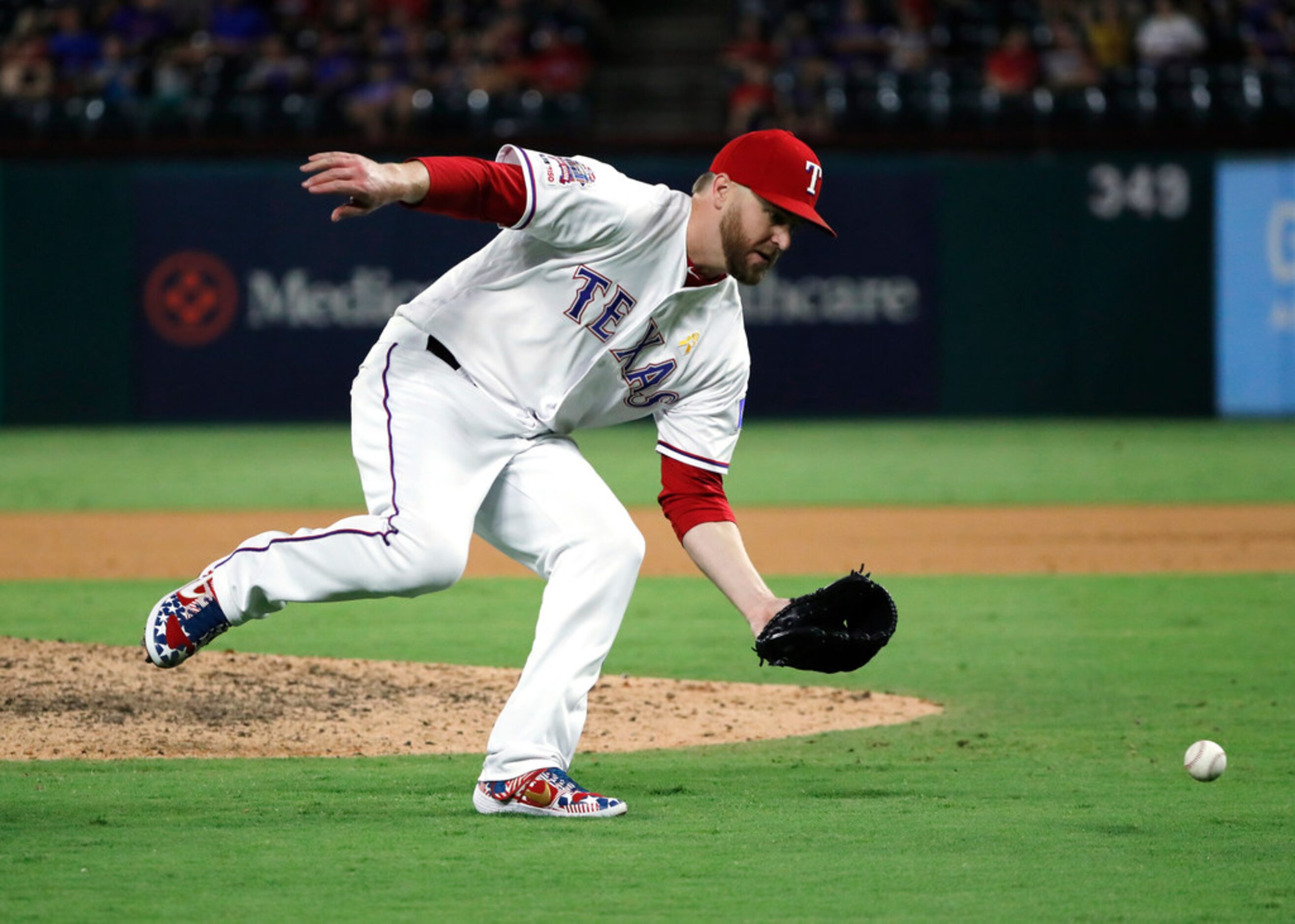 Texas Rangers relief pitcher Shawn Kelley reaches down to field a grounder by Oakland...