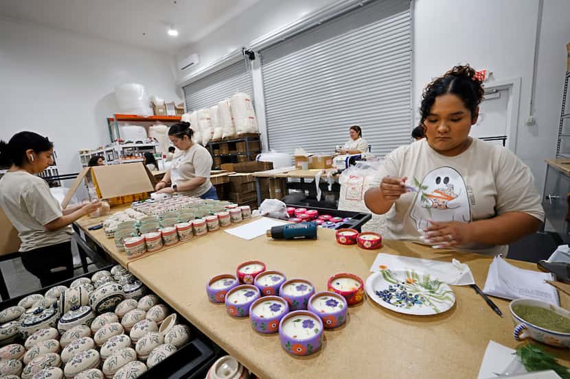 Romy Alfaro, right, places a topping on a candle at her sister Grecia Alfaro’s candle shop,...