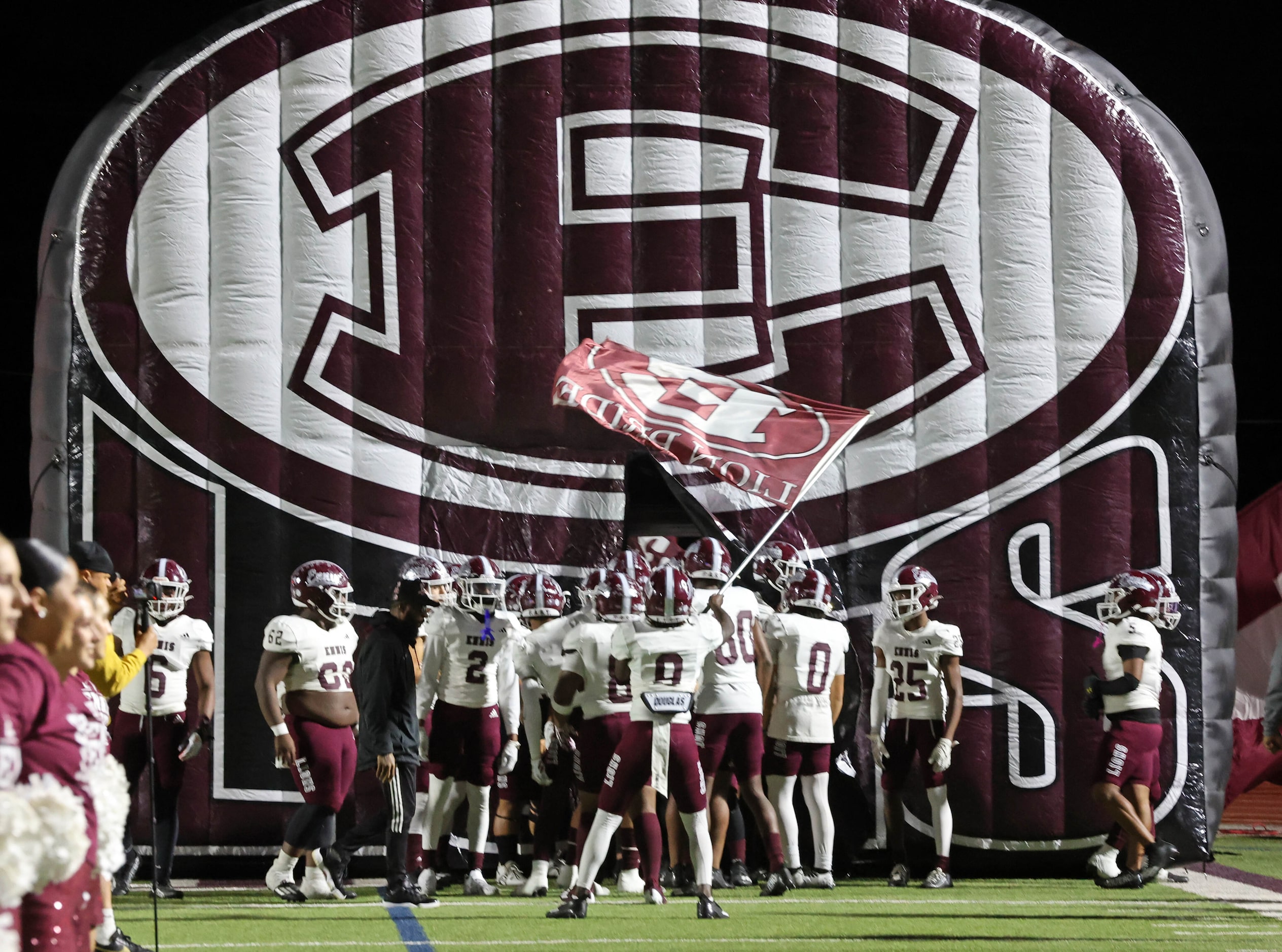 The Ennis Lions enter the field before the start of the first half of a high school football...