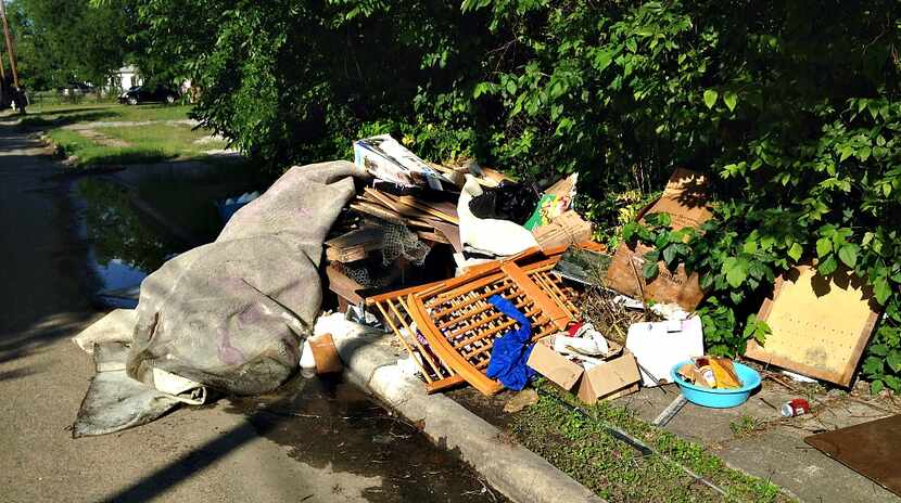 Trash heaps like this one along Herrling Street off Second Avenue in South Dallas are far...
