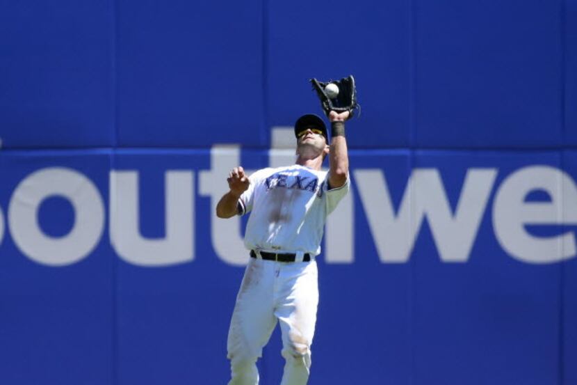 Texas Rangers left fielder Justin Ruggiano (25) catches a fly ball in the third inning...