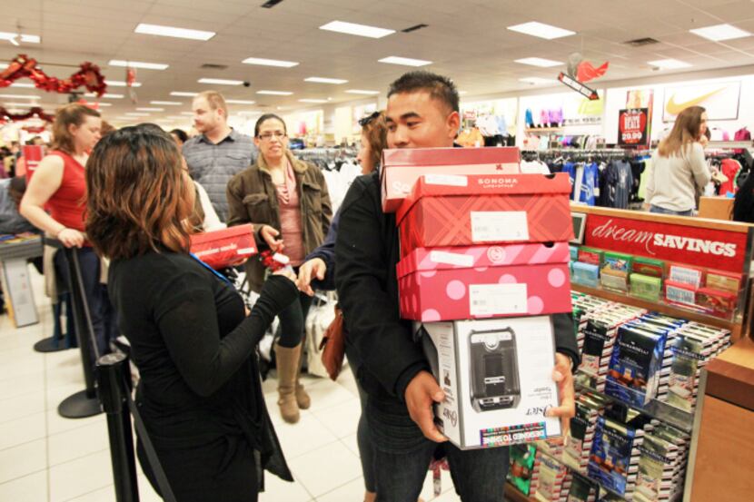 Fermin Rodriguez of Garland carries boxes of shoes and a toaster after waiting about an hour...