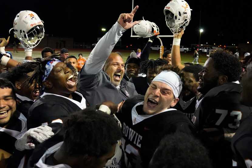 Arlington Bowie coach Danny DeArman celebrates with his players after a victory over...