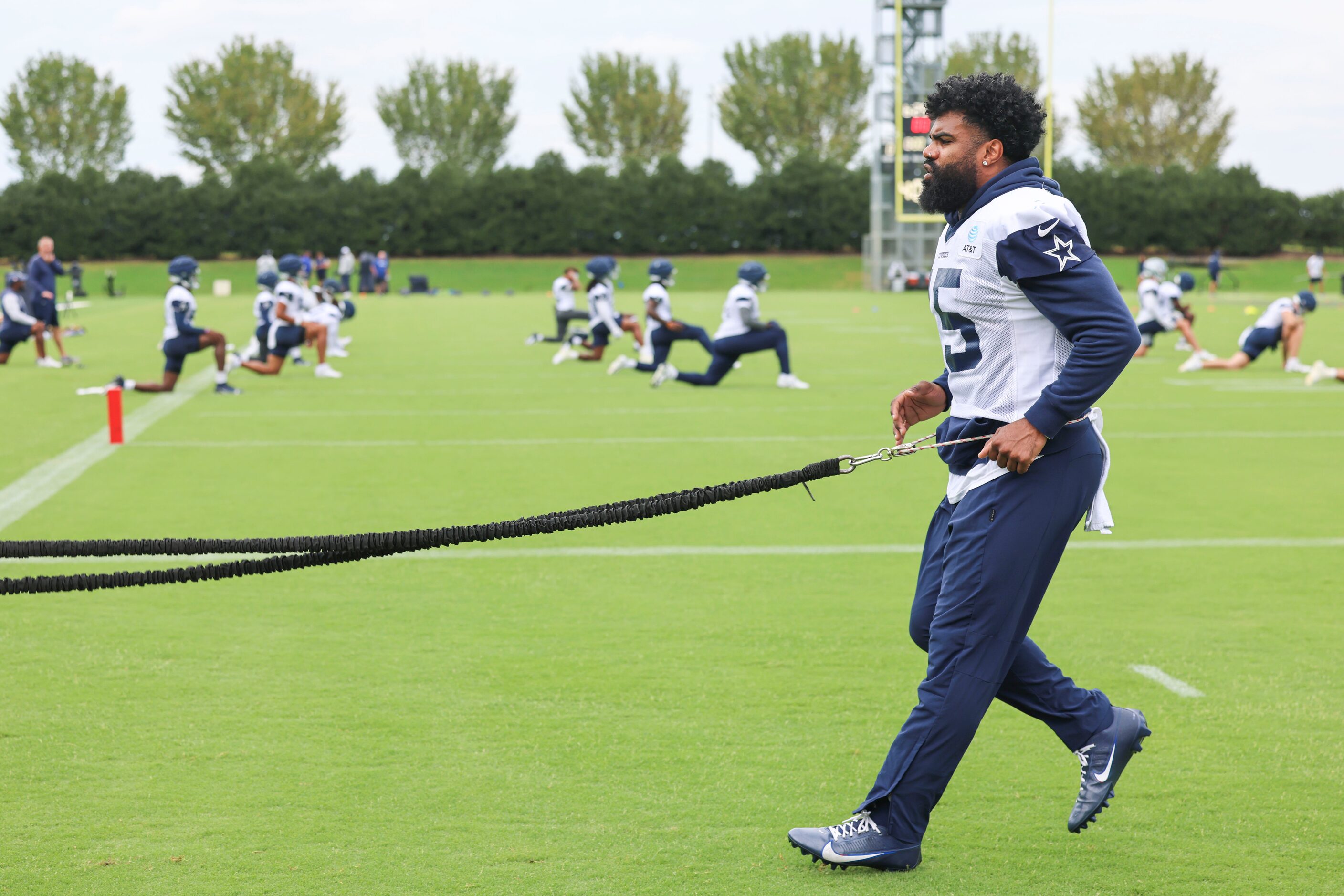 Dallas Cowboys running back Ezekiel Elliott (15) takes part in a drill during a team...