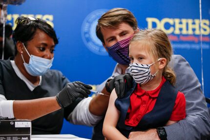 Matt Himelfarb sat with his daughter Bea, 6, as Barbara Davis administered the Pfizer...