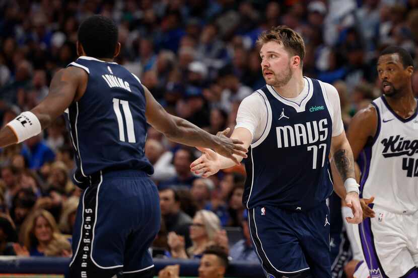 Dallas Mavericks guard Kyrie Irving (11) high fives guard Luka Doncic (77) after a basket...