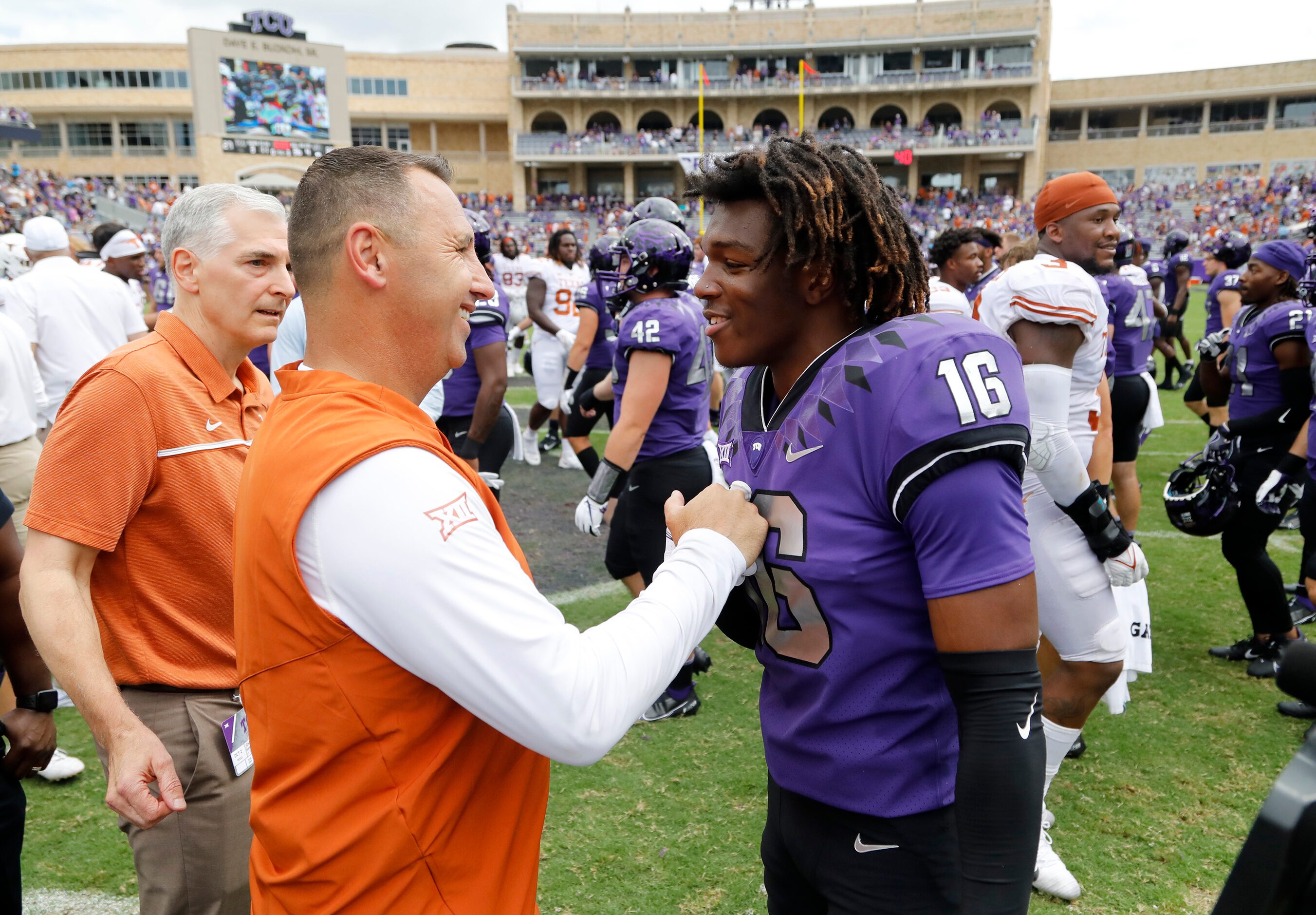 Texas Longhorns head coach Stephen Sarkisian greets TCU Horned Frogs safety D'Arco...