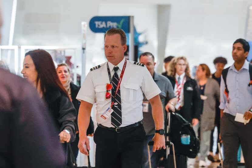 Southwest Airlines pilot Elden L. Hampton Jr. walks surrounded by travelers at the Dallas...