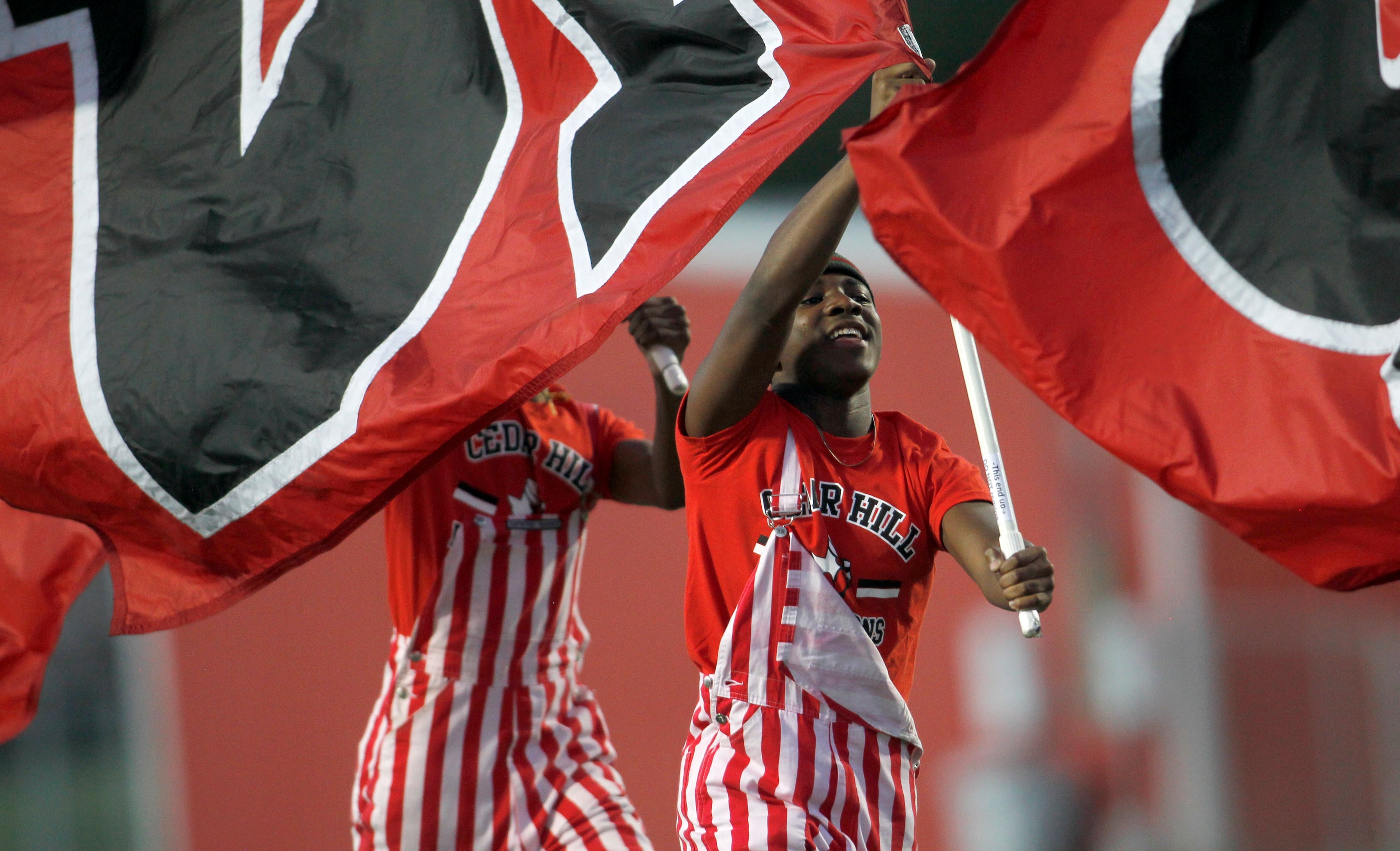 Cedar Hill flag wavers race across the field after a first half Longhorns touchdown in their...