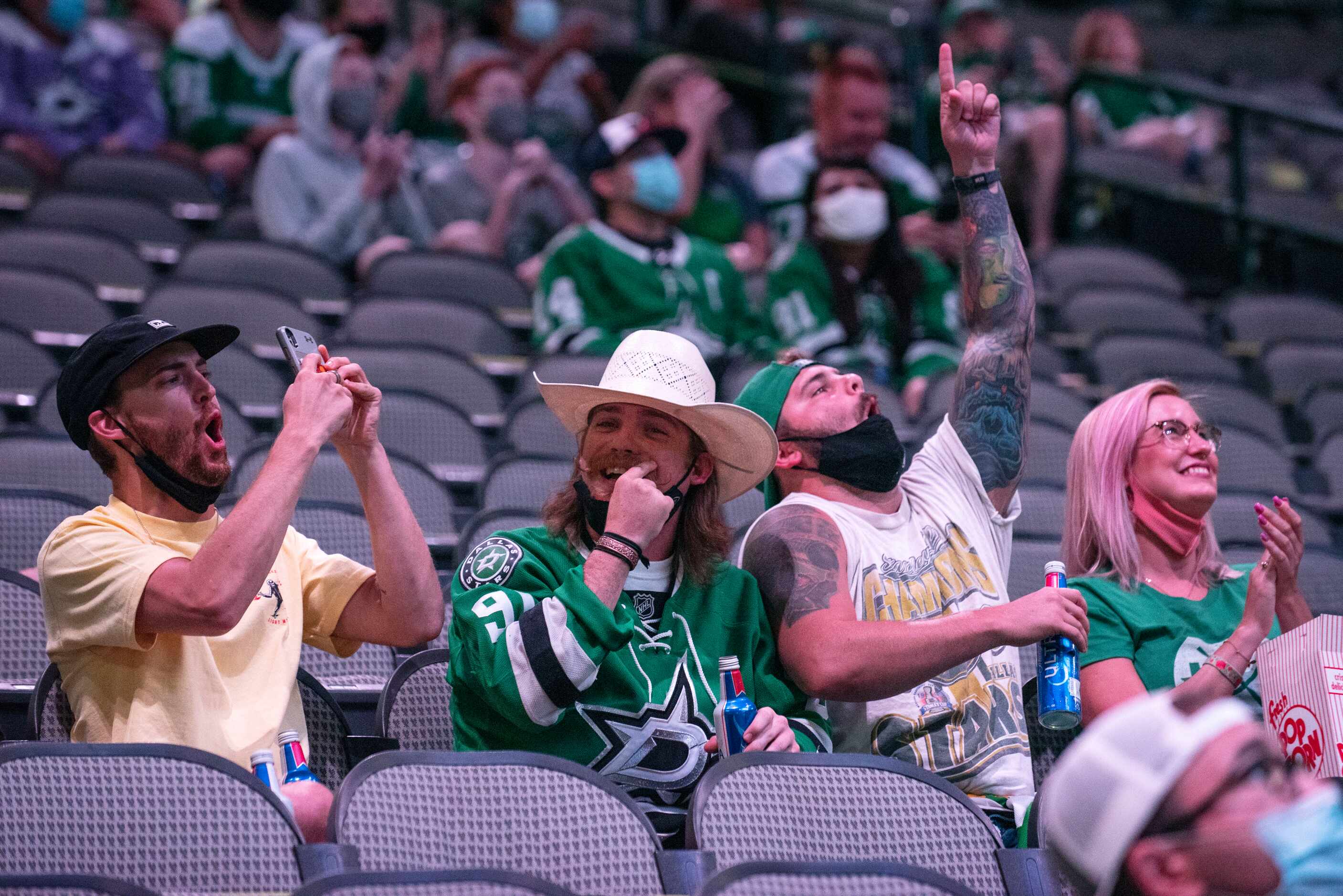 Dallas Stars fans react as they're shown on the jumbo screen during a commercial break of a...