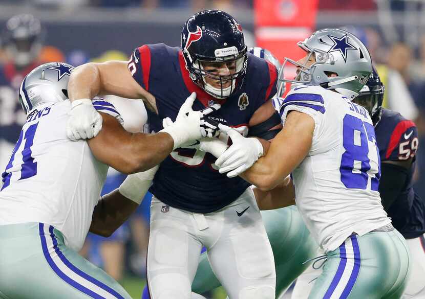 Houston Texans defensive end J.J. Watt (99) is blocked by Dallas Cowboys offensive tackle...