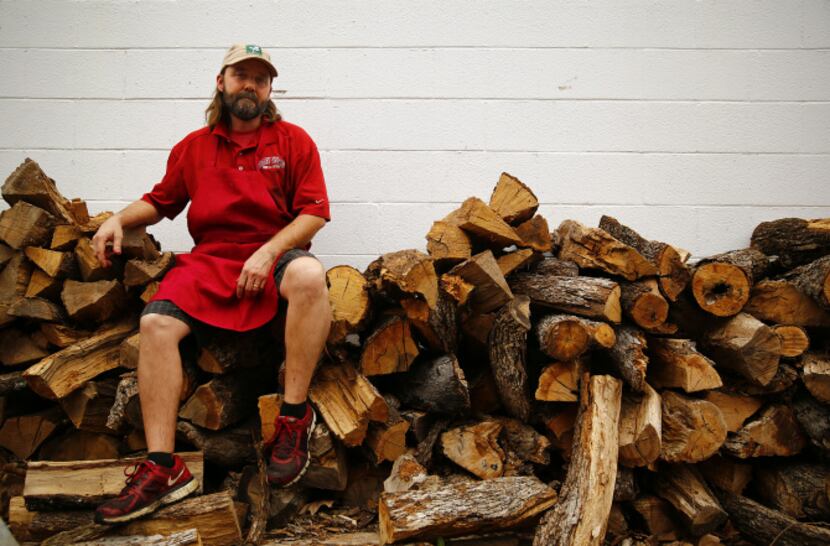 Stiles Switch BBQ & Brew pitmaster Lance Kirkpatrick poses for a photo on his oak wood pile...