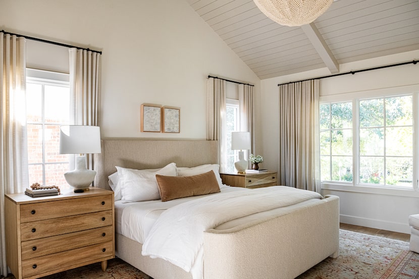 Bedroom outfitted in neutral colors, with large windows