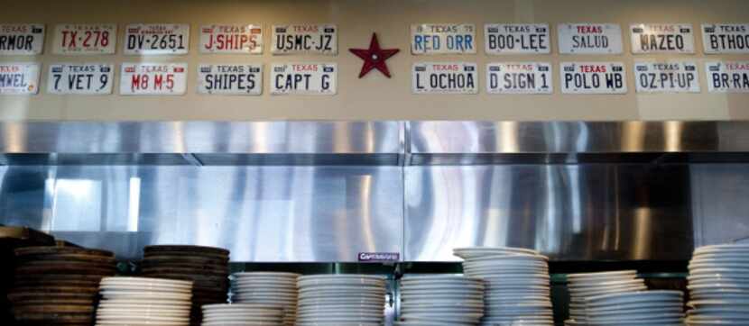Texas novelty license plates line the wall above the kitchen at the newest Hoffbrau Steaks...