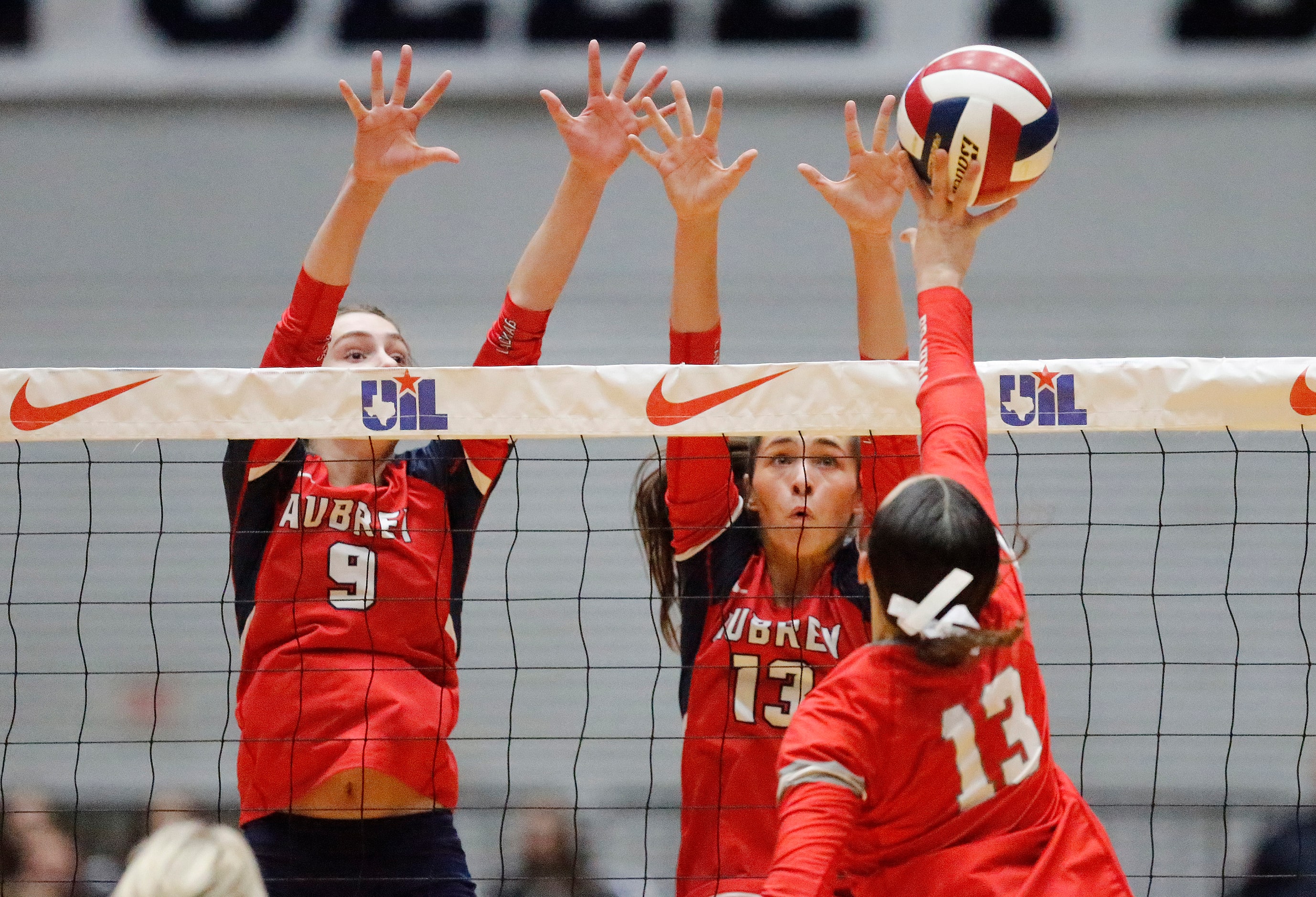 Aubrey High School’s Annaleise Sevier (9) and Sydney Garrison (13) attempt to block...