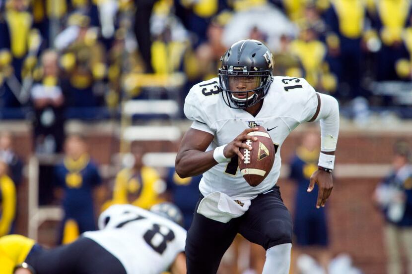 Central Florida quarterback Justin Holman (13) scrambles with the ball in the first quarter...