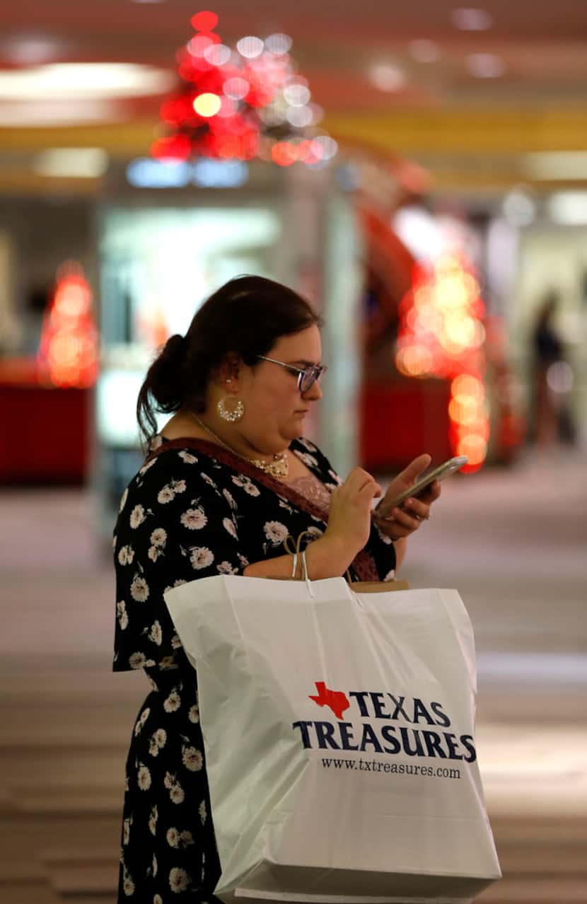 Brandi Bellanger checks her cell phone while shopping at Galleria Dallas in Dallas, Nov. 15,...