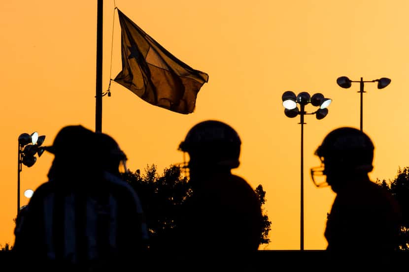 A Texas flag flies above a high school football game between Lancaster and Duncanville on...