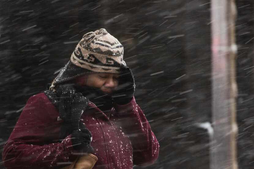 A woman shields her face during a winter storm in Philadelphia, Thursday, Feb. 9, 2017. A...