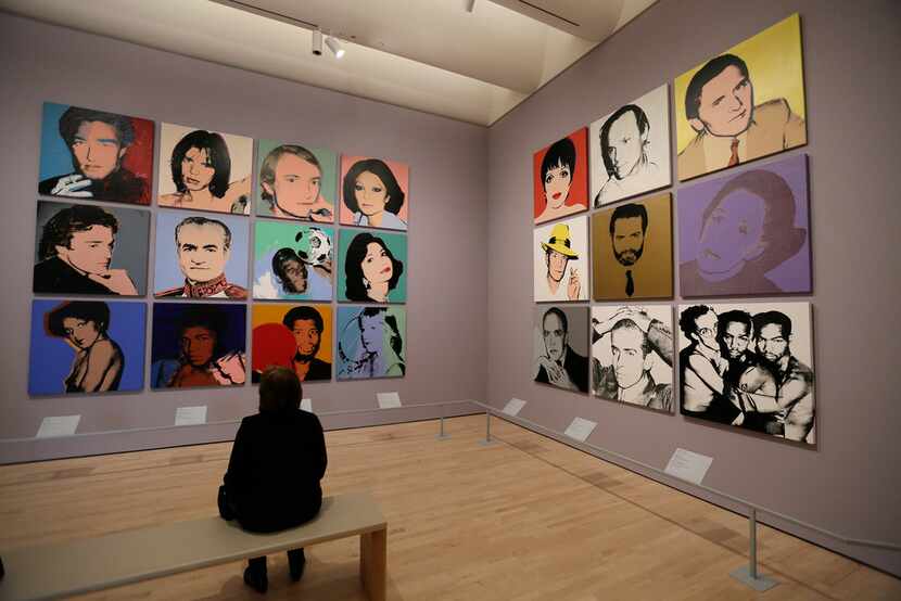 A woman views commissioned portraits created by Andy Warhol from 1968 to 1987 at the San...