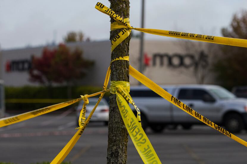 Police tape circled a tree outside the Macy's at Cascade Mall in Burlington, Wash.