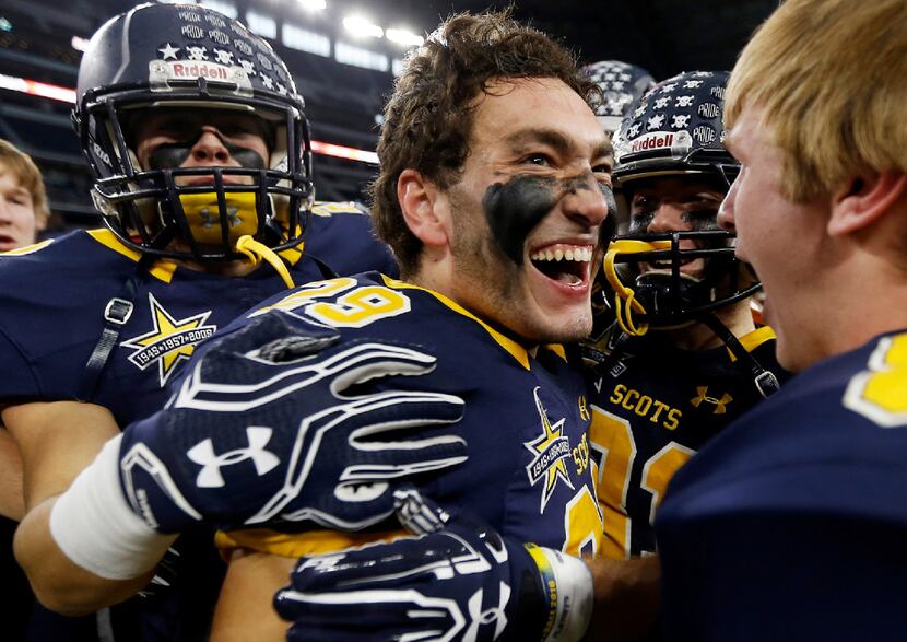 Highland Park junior safety Zak Folts (29) is congratulated by teammates after intercepting...