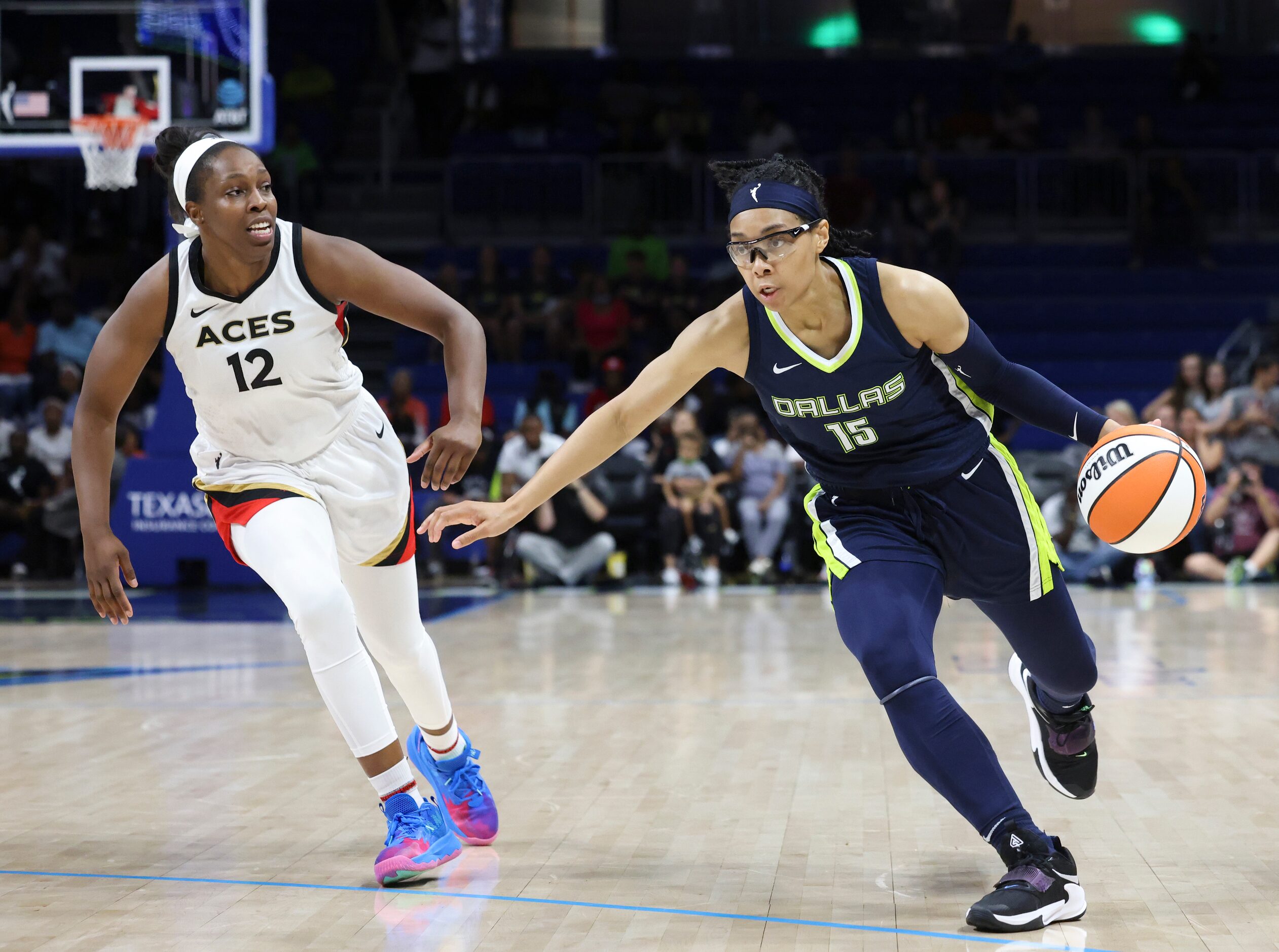 Las Vegas Aces guard Chelsea Gray (12) defends Dallas Wings guard Allisha Gray (15) as she...