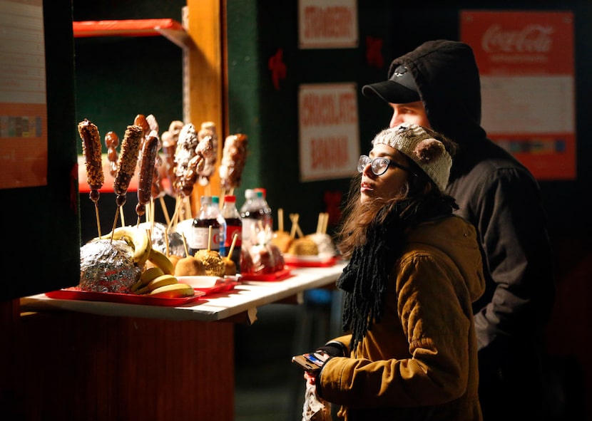 Natasha Tamula of Arlington looks at the menu before purchasing a caramel apple with her...