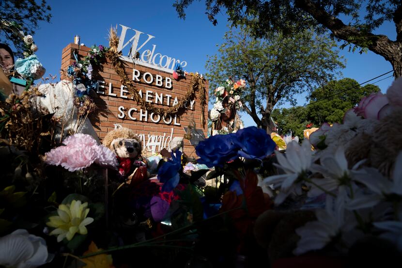 A memorial honoring the nineteen students and two teachers who were killed stands outside of...