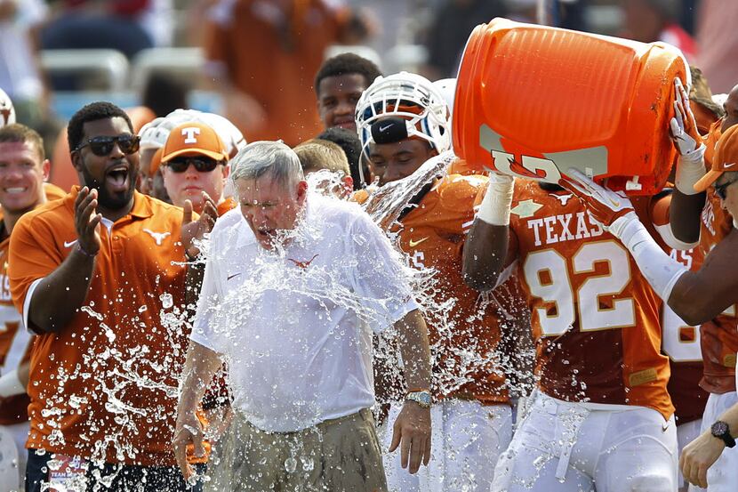 Texas head coach Mack Brown is doused with water by Texas players in the closing seconds of...