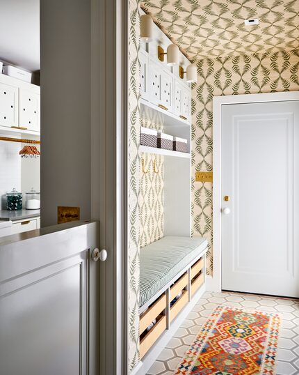 Mudroom area in stylish hallway with patterned wallpaper and an orange runner rug