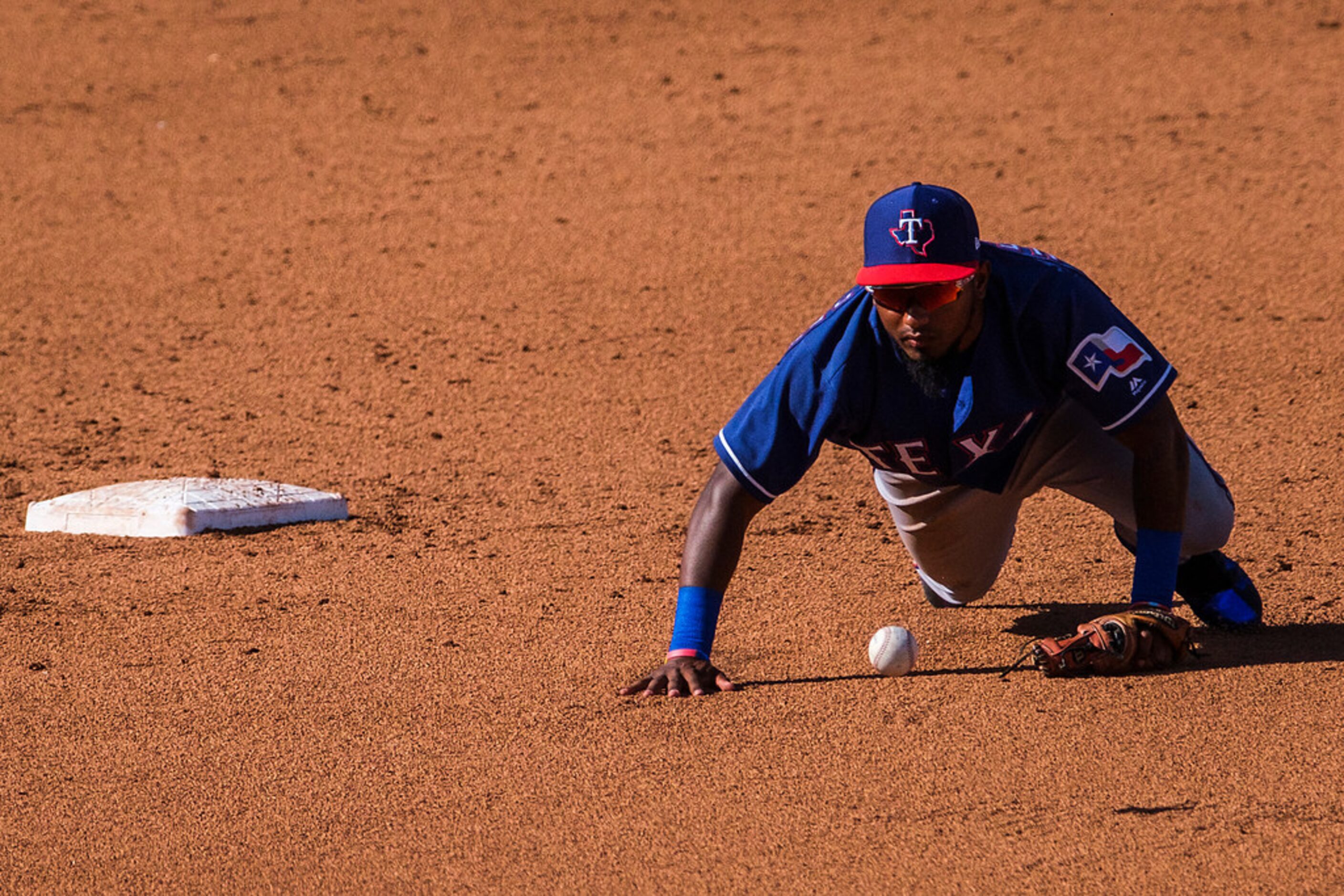 Texas Rangers infielder Yonny Hernandez chases an errant throw by Ben Revere during the...