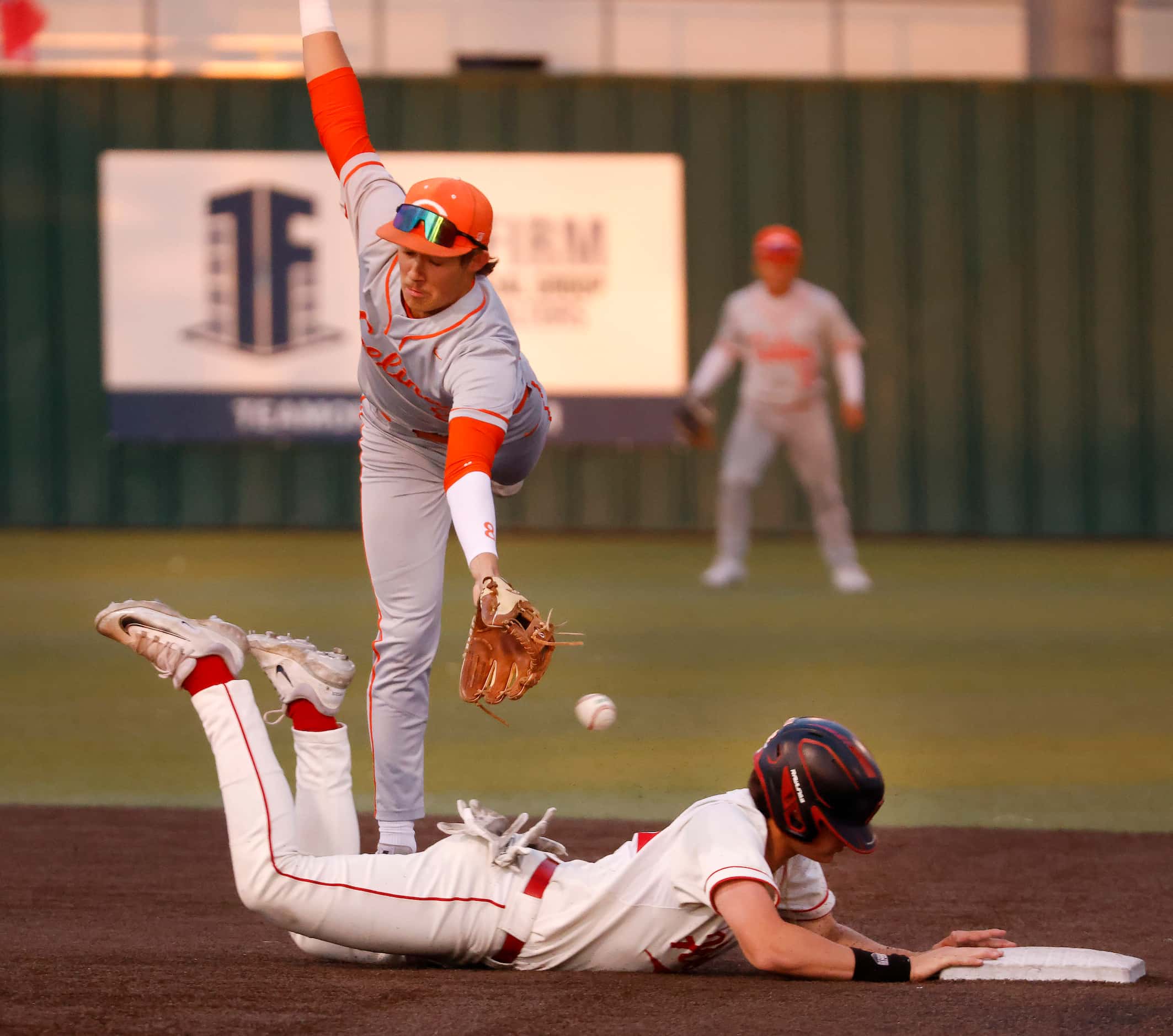 Rockwall-Heath High Brady Ladusau (22) dives safely back to second on a missed throw to...