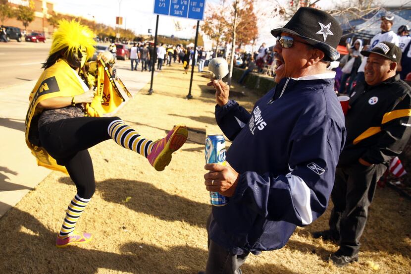 Cowboys fan Emilio Martinez of El Paso, left is kicked by Steelers friend and fan Jacqueline...