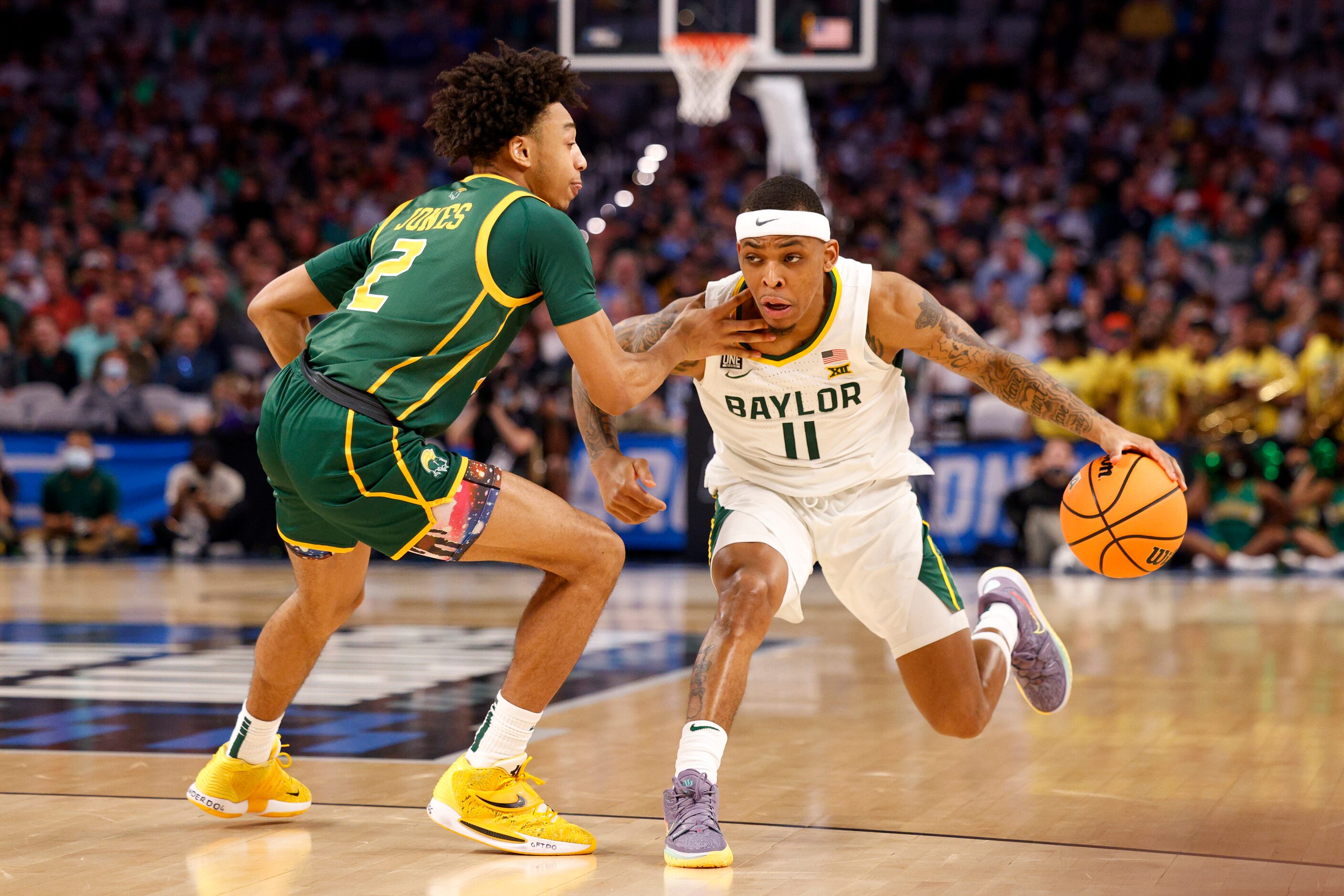 Baylor Bears guard James Akinjo (11) drives past n2\ during the second half of a first round...