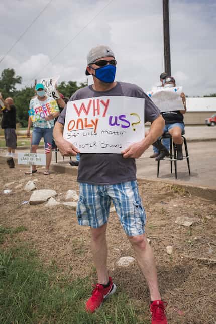 Rodney Worley held a sign that says "Why only us? Bar lives matter" at a protest at Cooter...