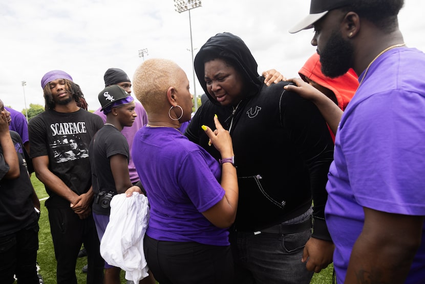 LaRae Williams, mother of Khamoni Williams, and her son Kris Walker, right, talk to her...